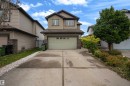 Two-story residence featuring a front-facing garage, stone veneer accents, and a concrete driveway - 3230 21A Avenue Nw, Edmonton, AB 