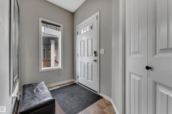 Entryway featuring a white paneled door with glass inserts, an adjacent window, and neutral wall tones - 