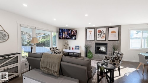 Recessed lighting, wood-finish flooring, and a fireplace with a stone surround - 3508 106A Street Nw, Edmonton, AB 