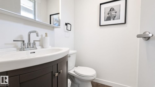 Vanity with dark wood cabinetry, integrated basin, and polished chrome faucet - 3508 106A Street Nw, Edmonton, AB 