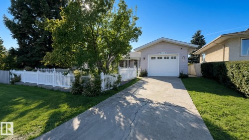 Light-colored siding exterior with an attached garage, featuring a white garage door with window panels - 3508 106A Street Nw, Edmonton, AB 