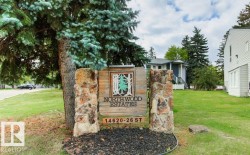 Stone and wood-finish signage with established landscaping - 