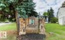 Stone and wood-finish signage with established landscaping - #4 14620 26 St Nw, Edmonton, AB 