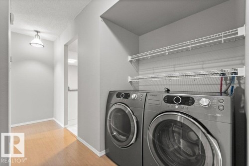 Dedicated laundry area with wire shelving and wood-finish flooring - #4 14620 26 St Nw, Edmonton, AB 