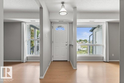Entry door with an arched window detail and a ceiling-mounted light fixture - #4 14620 26 St Nw, Edmonton, AB 
