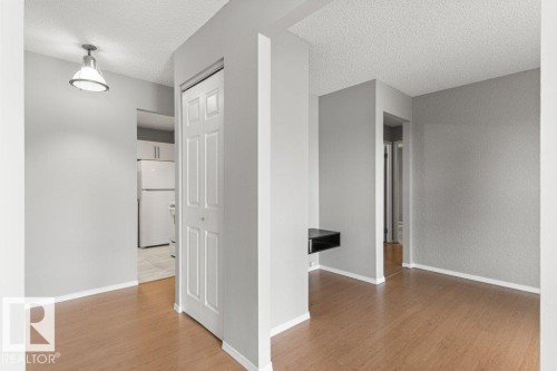 Light wood-finish flooring with white trim - #4 14620 26 St Nw, Edmonton, AB 