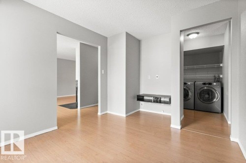 Wood-finish flooring throughout, with light gray painted walls - #4 14620 26 St Nw, Edmonton, AB 