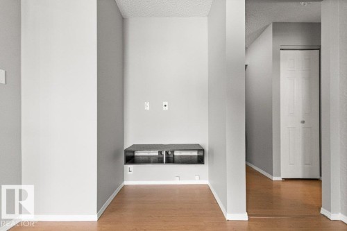 Recessed wall niche with a built-in media console, wood-finish flooring, and light gray wall paint - #4 14620 26 St Nw, Edmonton, AB 