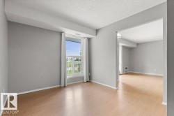 Light wood-finish flooring throughout, bright window with white trim, and a neutral wall palette - 
