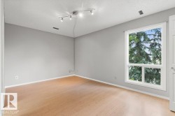 Wood-finish flooring, white trim, track lighting fixture, and a large multi-pane window - 