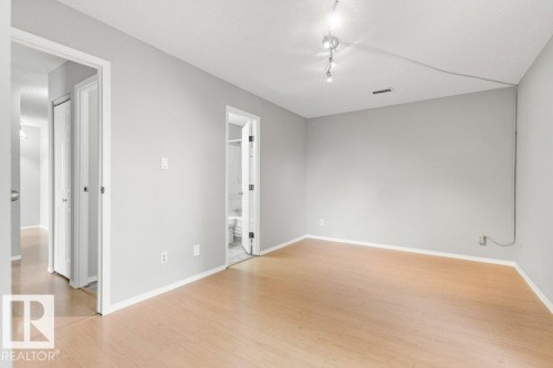 Light wood-finish flooring with white trim - #4 14620 26 St Nw, Edmonton, AB 