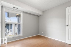 Bright interior with wood-finish flooring, white trim, and a white paneled door - 