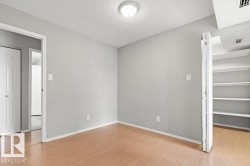 Light wood-finish flooring, built-in shelving, white trim, and flush-mount ceiling lighting - 