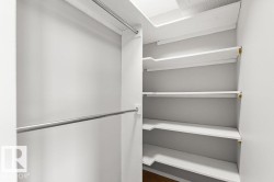 Built-in shelving, chrome hanging rods, and wood-finish flooring - 
