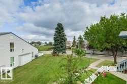 Expansive green space featuring mature trees and a manicured lawn - 