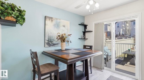 Dining area featuring light blue wall accents, a multi-tiered corner shelf, and light wood-finish flooring - 1709 64 Street Sw, Edmonton, AB 