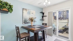 Dining area featuring light blue wall accents, a multi-tiered corner shelf, and light wood-finish flooring - 