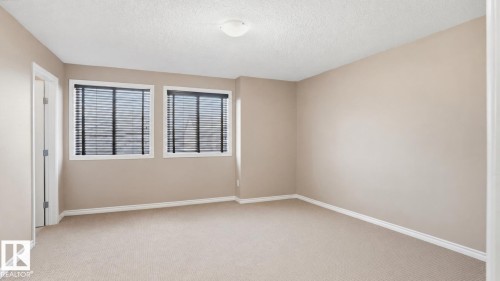 Neutral-toned walls complement carpeted flooring and white trim - 1709 64 Street Sw, Edmonton, AB 