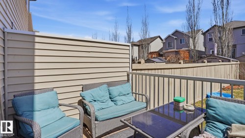 Outdoor patio featuring vinyl siding privacy wall and wooden railing - 1709 64 Street Sw, Edmonton, AB 