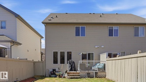 Rear exterior with horizontal siding, multiple windows, and a sliding glass door - 1709 64 Street Sw, Edmonton, AB 