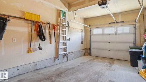 Attached garage with a sectional overhead door and upper window panels - 1709 64 Street Sw, Edmonton, AB 