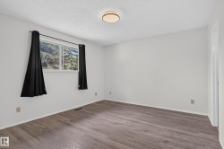 Wood-finish flooring, white walls, and a contemporary ceiling light fixture - 