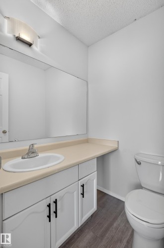 White vanity with cabinet storage, integrated sink, and light-toned countertop - 3722 34A Avenue Nw, Edmonton, AB 