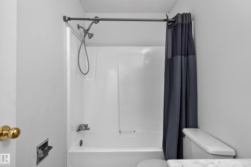White tub/shower combination with a chrome shower head and faucet - 3722 34A Avenue Nw, Edmonton, AB 