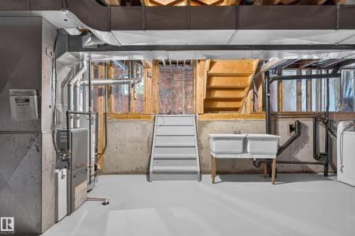 Finished basement space featuring concrete walls, exposed ceiling joists, and a utility sink - 3722 34A Avenue Nw, Edmonton, AB 