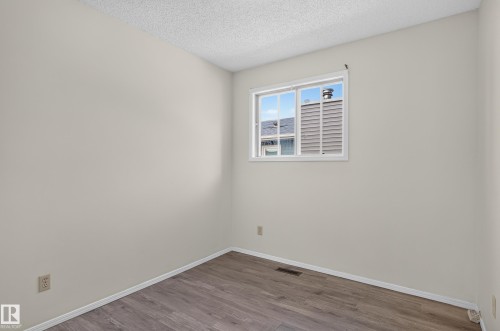 Light-colored walls, wood-finish flooring, white window trim, and white baseboards - 3722 34A Avenue Nw, Edmonton, AB 