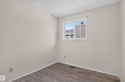 Light-colored walls, wood-finish flooring, white window trim, and white baseboards - 