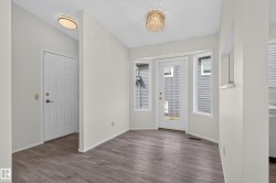 Wood-finish flooring, bay window with multiple panes, and a glass-paneled exterior door - 