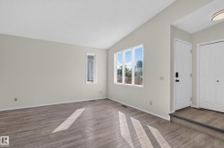 Vaulted ceiling, wood-finish flooring, multiple windows, white doors, recessed entry - 