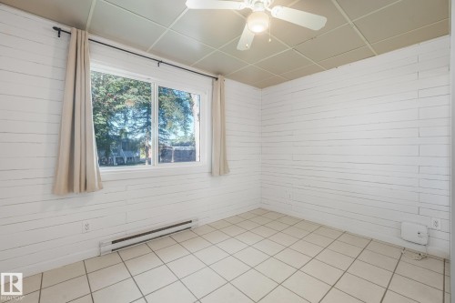 White shiplap walls, recessed ceiling panels, white ceiling fan with integrated lighting, and light-toned tile flooring - 11841 71 Street Nw, Edmonton, AB 