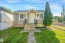 Wood-paneled facade with white trim windows and a prominent entry - 11841 71 Street Nw, Edmonton, AB 