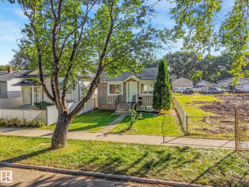 Siding exterior with a covered entry, front walkway, and mature landscaping - 11841 71 Street Nw, Edmonton, AB 