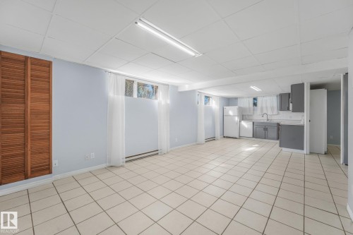 Open-concept space featuring tile flooring, a drop ceiling, and recessed windows - 11841 71 Street Nw, Edmonton, AB 
