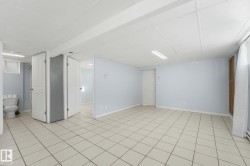 Tile flooring, drop ceiling, recessed lighting, white panel doors, and light blue wall color - 