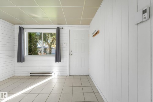 White paneled walls, tiled flooring, drop ceiling, and a functional window - 11841 71 Street Nw, Edmonton, AB 