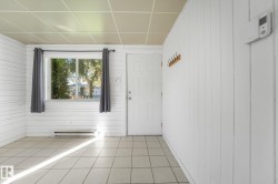 White paneled walls, tiled flooring, drop ceiling, and a functional window - 