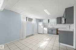 Tile flooring, light blue wall paint, window, gray cabinetry, white subway tile backsplash - 