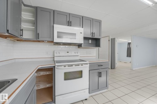 Contemporary kitchen featuring gray cabinetry, white subway tile backsplash, white countertops, and white appliances - 11841 71 Street Nw, Edmonton, AB 