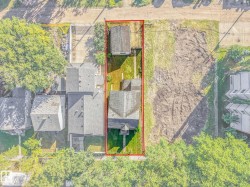 Property featuring a main residence with a gabled roof, an additional detached structure with a gabled roof, and a grassy lawn space - 