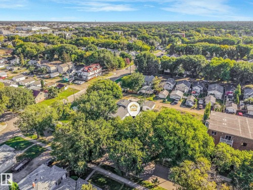 Aerial view showcasing mature landscaping with established trees throughout the property and surrounding neighborhood, situated on a tree-lined street with multiple residential homes visible across the community - 11841 71 Street Nw, Edmonton, AB 