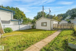 Detached garage with wood fencing and a concrete walkway - 