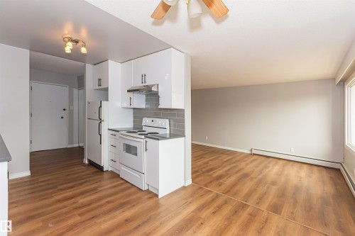 Kitchen area featuring white cabinetry, a subway tile backsplash, and a white appliance suite - Edmonton, AB - Indoor Photo Showing Kitchen