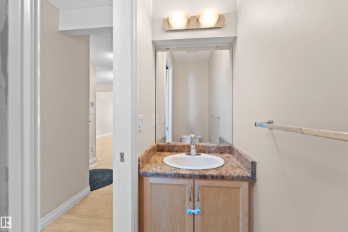 Vanity with a brown-toned countertop and an integrated sink, illuminated by a two-light fixture - 15504 102 Avenue Nw, Edmonton, AB 