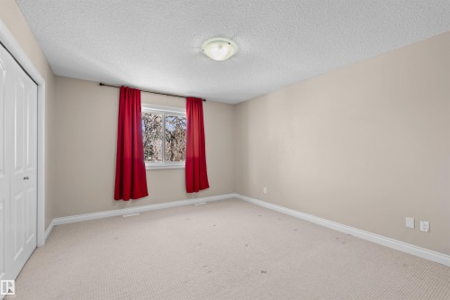 Carpeted flooring, neutral wall color, ceiling-mounted light fixture, white trim, and a bi-fold closet - 15504 102 Avenue Nw, Edmonton, AB 