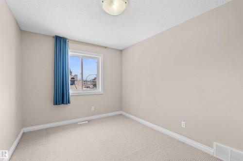 Carpeted flooring, neutral wall color, white trim, and a flush mount ceiling light - 15504 102 Avenue Nw, Edmonton, AB 