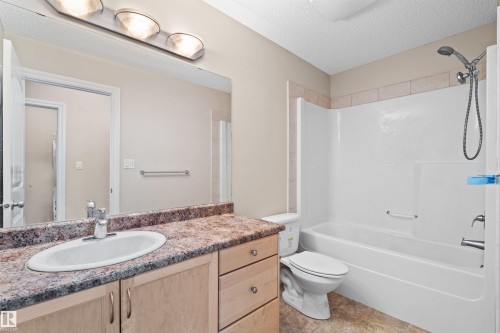 Vanity with an integrated sink, a speckled countertop, and light wood-finish cabinetry - 15504 102 Avenue Nw, Edmonton, AB 